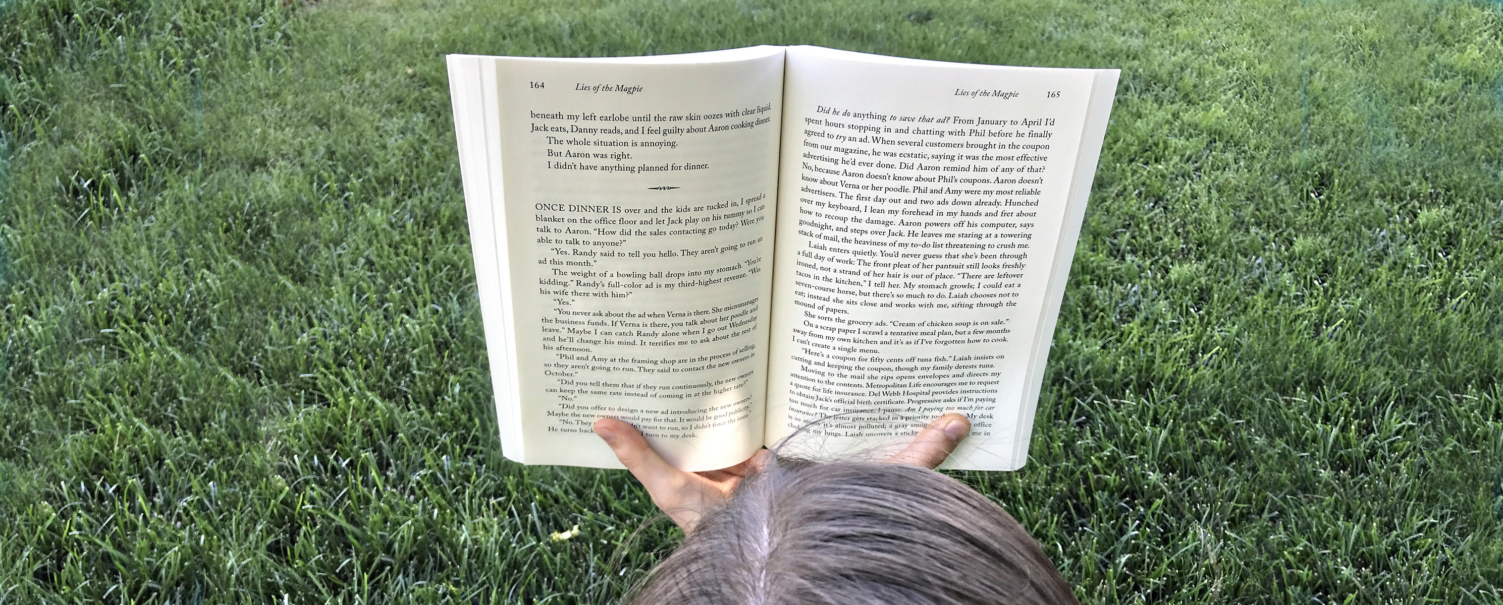 Woman in grass reading book