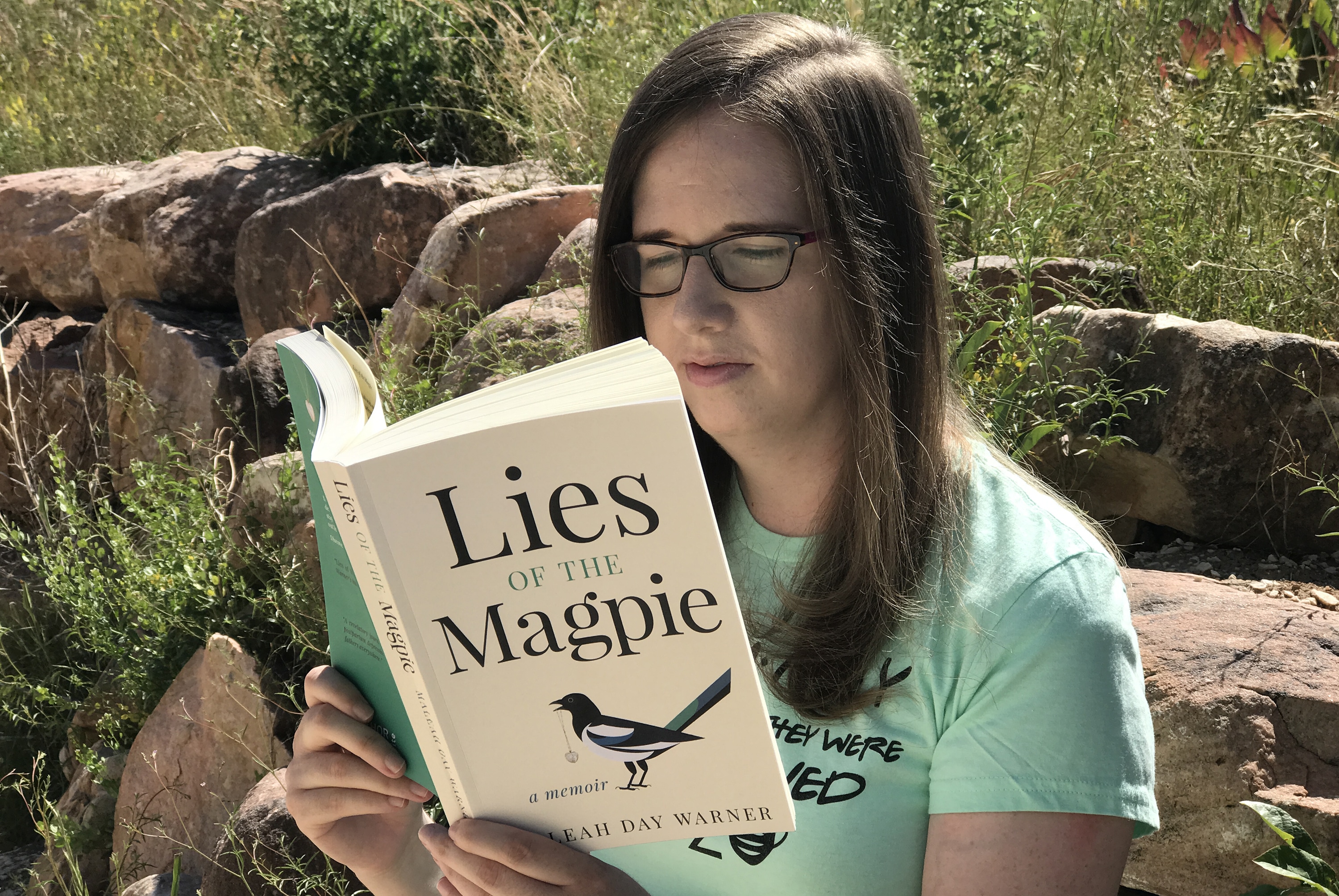 Woman reading the memoir Lies of the Magpie